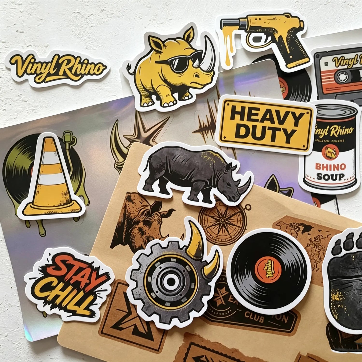 Vinyl Rhino sticker sample kit including assorted die-cut vinyl decals like retro cassettes and rhino mascots displayed on professional packaging envelopes.